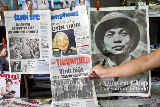 Một người đàn ông cầm tờ báo với hình ảnh của Đại tướng Võ Nguyên Giáp trên trang nhất ở một quầy báo tại Hà Nội. Nguồn: European Pressphoto Agency
