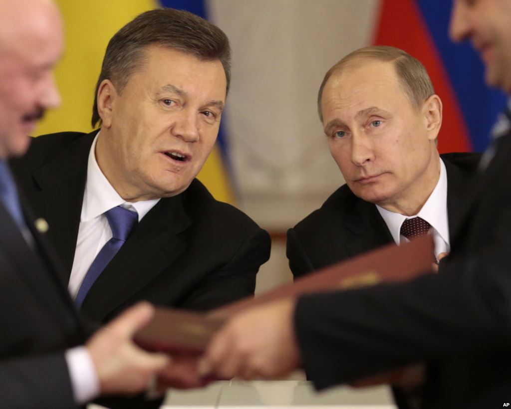 Tổng thống Nga Vladimir Putin, phải, và người đồng nhiệm Ukraina Viktor Yanukovych của mình, trái, phản ứng sau khi ký kết thỏa thuận tại Moscow, 17 tháng 12 2013. Nguồn: AP