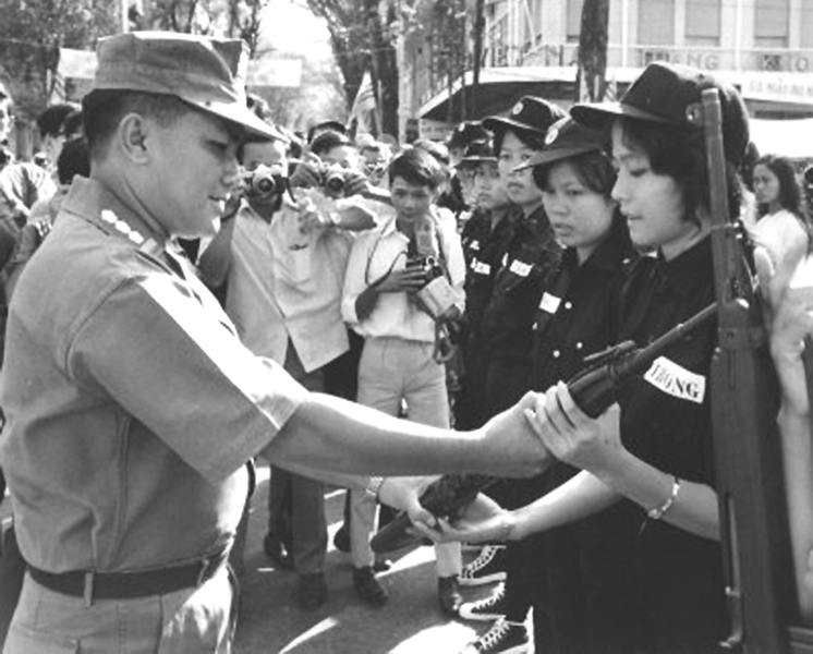 Đô trưởng Saigon-Gia Định, Đại tá Đỗ Kiến Nhiễu trao vũ khí cho nữ đội viên Nhân dân tự vệ. Tháng 8/1969. Nguồn flickr.com