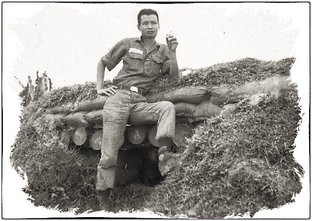 Chuẩn úy Nguyễn Văn Uy trước hầm trú ẩn ở đồn Nora, vùng núi Tà Dôn, Bình Thuận. 1969. Nguồn Thư quán Brn thảo số tháng 2/2005