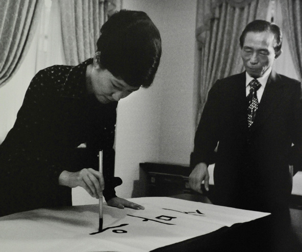Park Geun-hye (L) uses a writing brush to write calligraphy as her father, the late South Korean President Park Chung-hee, looks on in Seoul in this August 31, 1977 picture which Reuters obtained August 27, 2012. Park Geun-hye was picked as the presidential candidate of the ruling conservative and right-wing Saenuri Party on August 20, 2012. Park is the daughter of former military dictator Park Chung-hee who took power in a military coup in 1961 and ruled until his assassination in 1979. Park's frugal lifestyle as a single woman living in a modest house in the capital Seoul, her simple clothes and 1970s hairstyle recall the look and life of her mother, Yuk Young-soo. Picture taken August 31, 1977. To match Feature KOREA-POLITICS/PARK REUTERS/The Ministry of Culture, Sports and Tourism/Handout (SOUTH KOREA - Tags: POLITICS) FOR EDITORIAL USE ONLY. NOT FOR SALE FOR MARKETING OR ADVERTISING CAMPAIGNS. THIS IMAGE HAS BEEN SUPPLIED BY A THIRD PARTY. IT IS DISTRIBUTED, EXACTLY AS RECEIVED BY REUTERS, AS A SERVICE TO CLIENTS - RTR377K3