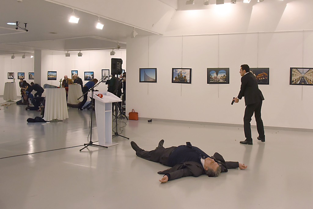 Một người đàn ông, bên phải, theo tin của AP là sát thủ, sau bắn chết đại sứ Nga, nằm trên sàn, vào thứ Hai – 19 tháng 12 – tại một phòng triển lãm ở Ankara, thủ đô của Thổ Nhĩ Kỳ. Nguồn: Yavuz Alatan / Agence France-Presse - Getty Images
