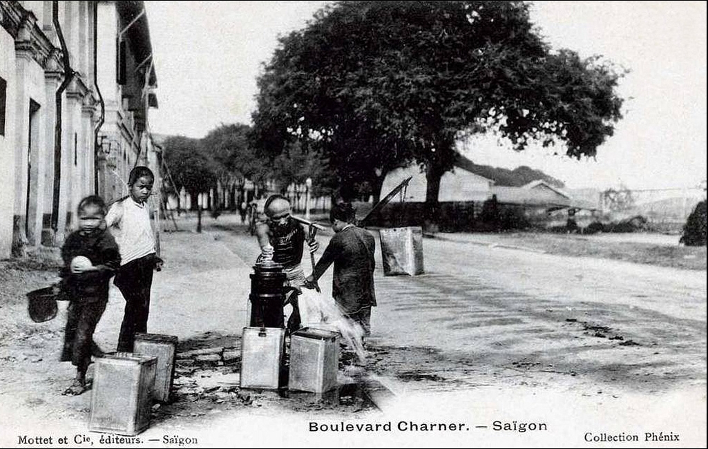 Gánh nước. Saigon - boulevard Charner. Đây là đường Bến Chương Dương, đoạn gần cầu Mống (thấy mờ mờ ở phía bên phải ảnh), nhưng trên postcard ghi là ĐL Charner.
