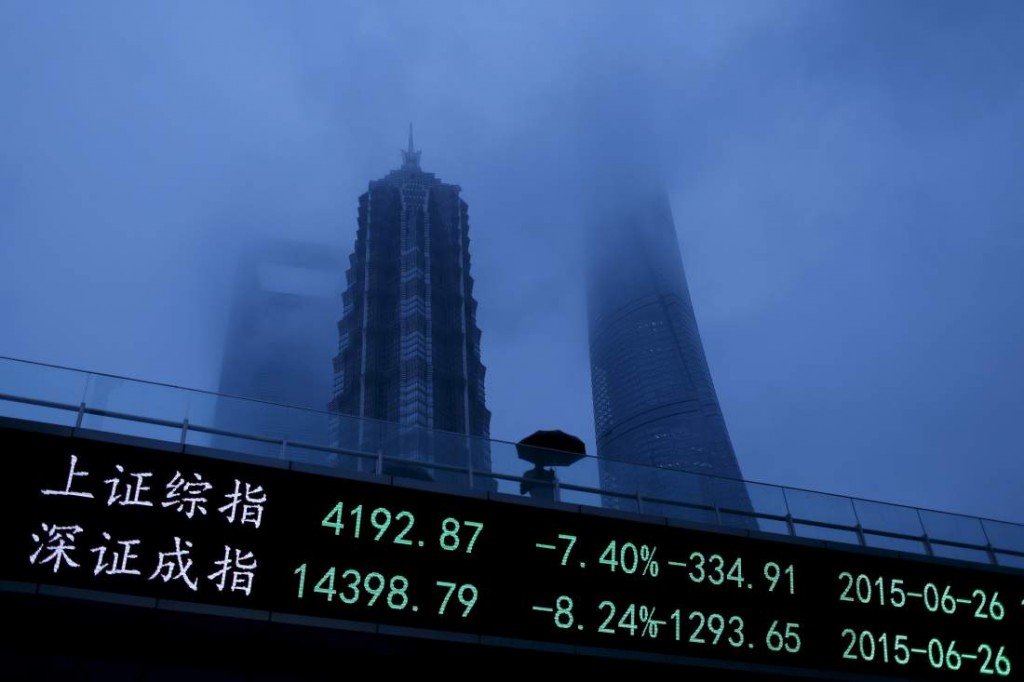 A man walks past an electronic board showing the benchmark Shanghai and Shenzhen stock indices, on a pedestrian overpass at the Pudong financial district in Shanghai, China, June 26, 2015. Chinese stocks plunged over 7 percent on Friday, with one key index recording its biggest fall since 2008, hit by tight liquidity conditions ahead of the quarter-end and uncertainty over the central bank's easing policy. REUTERS/Aly Song      TPX IMAGES OF THE DAY      - RTX1HVU8