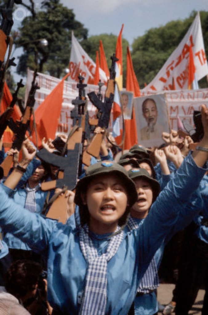 Ngày 30 tháng tư năm 1975 Sài Gòn, Nam Việt Nam --- Nữ quân đội Bắc Việt vào Sài Gòn mang súng trường bằng gỗ, cờ đỏ, và chân dung Hồ Chí Minh. --- Hình ảnh của © Jacques Pavlovsky / Sygma / Corbis Nguồn: 